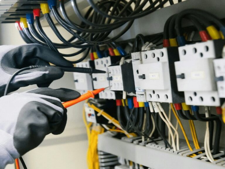 Elektryk sprawdza rozdzielnicę miernikiem